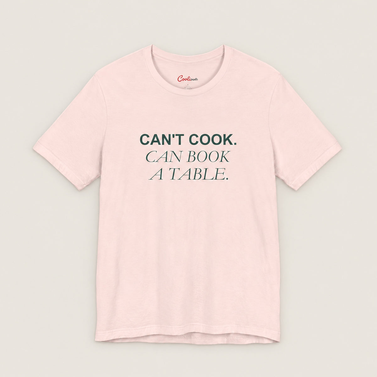 Can't Cook, Can Book a Table Bella+Canvas 3001 T-shirt in Soft Pink, front flat lay.