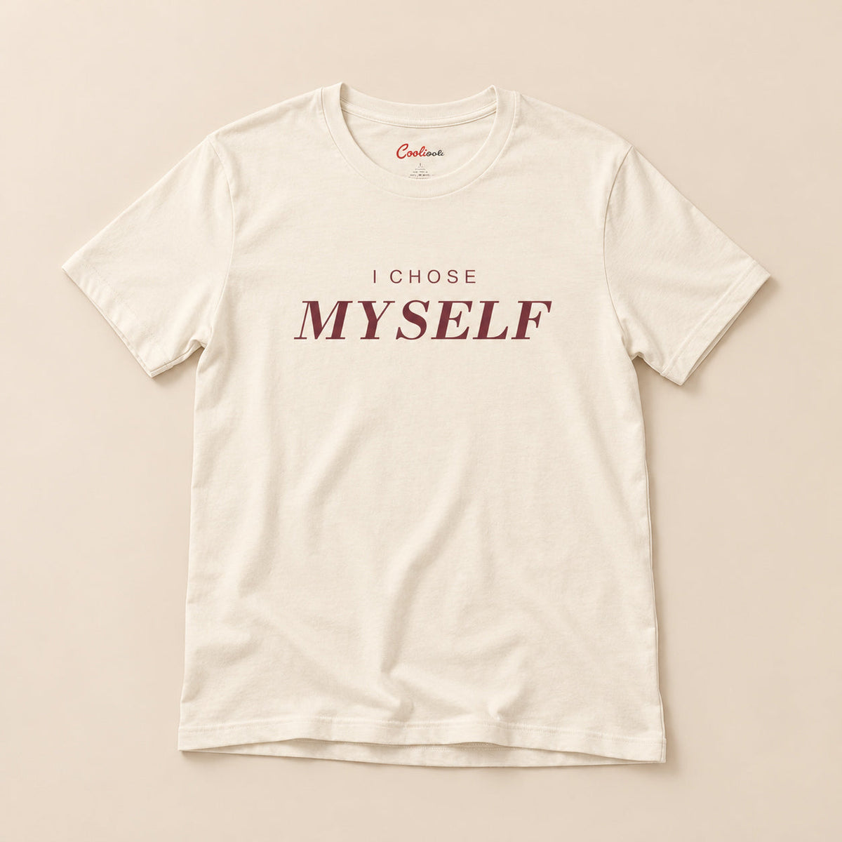 Her First Choice. Natural Bella+Canvas 3001 T-shirt with I CHOSE MYSELF lettering, complete overhead flat lay on a warm neutral background.