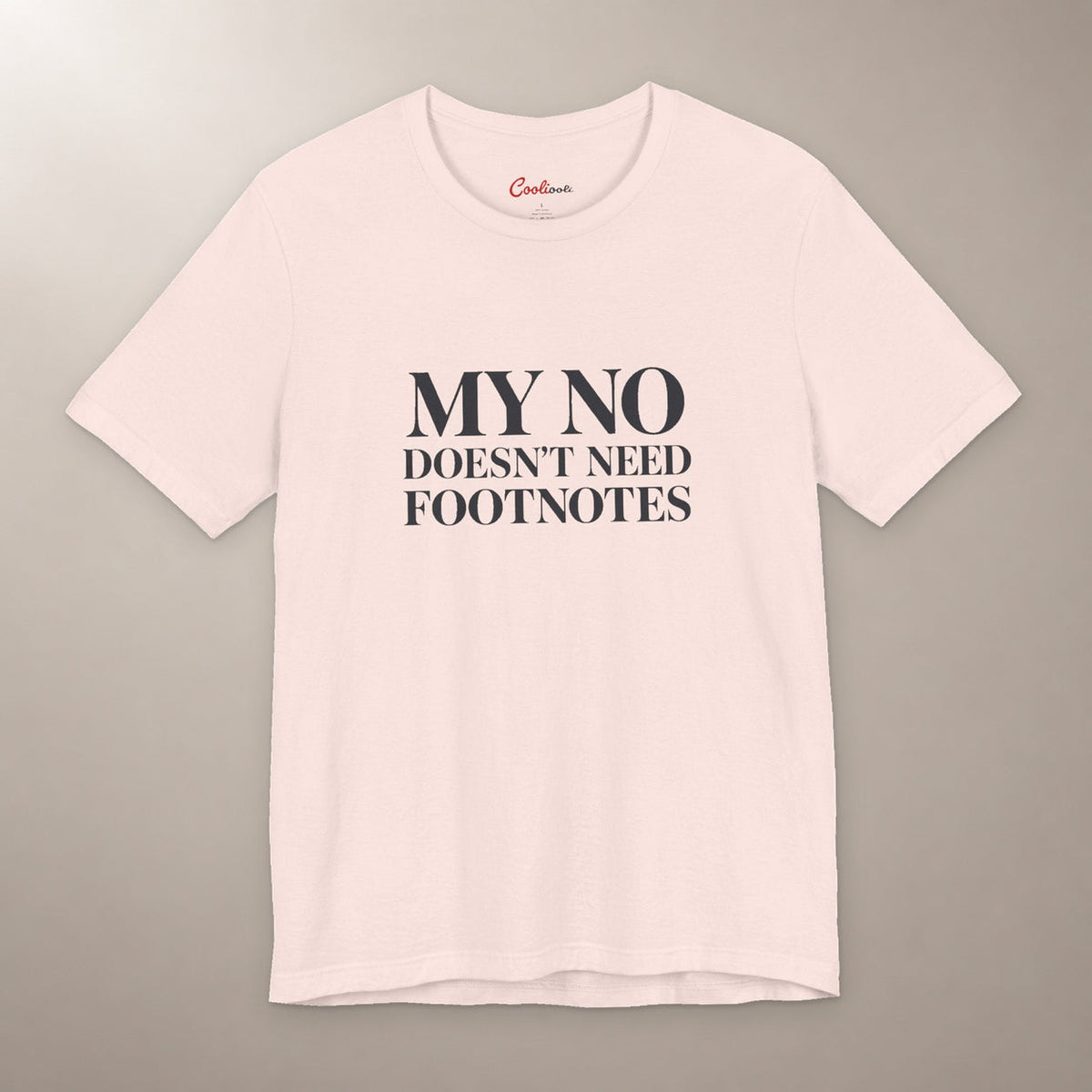 No Means No. Conversation Over. Bella+Canvas 3001 T-shirt in Soft Pink, front flat lay with My No Doesn’t Need Footnotes serif lettering on a plain warm neutral background.