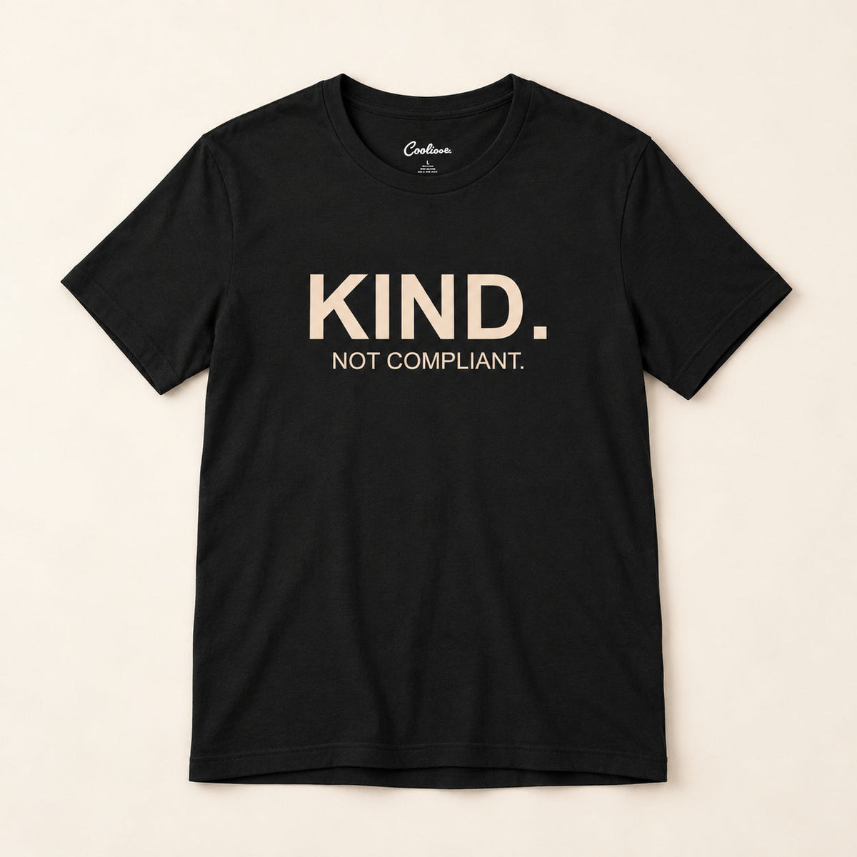Kind. Not Compliant. affirmation tee in Black on a neutral studio background