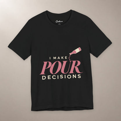 Blame the Vintage. Bella+Canvas 3001 T-shirt in Black, front flat lay with I Make Pour Decisions lettering and a tilted wine bottle on a plain warm neutral background.