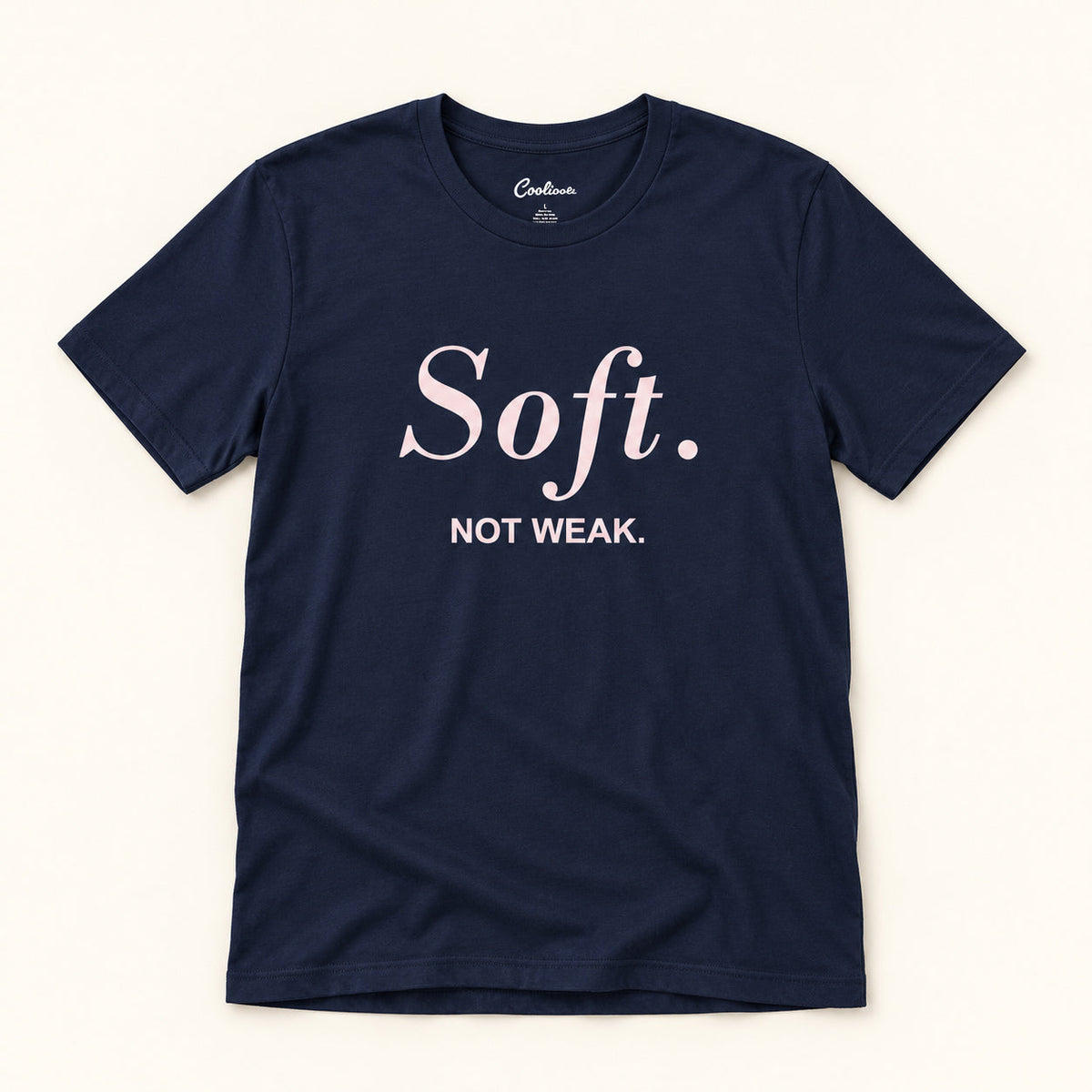 Soft. Not Weak. affirmation tee in Navy on a warm neutral studio background
