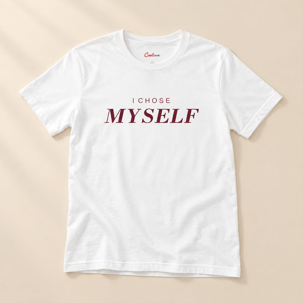 Her First Choice. White Bella+Canvas 3001 T-shirt with I CHOSE MYSELF lettering, complete overhead flat lay on a warm neutral background.