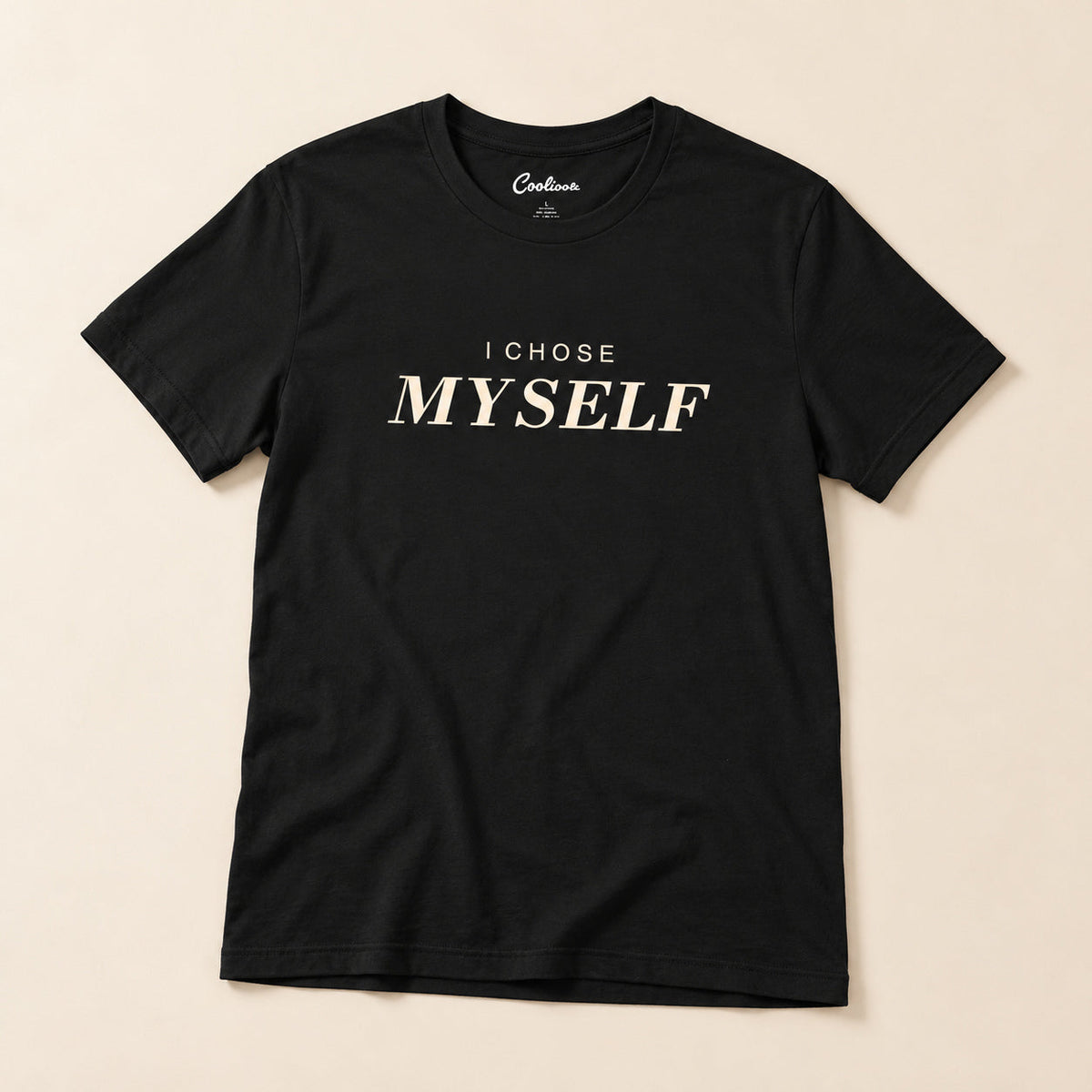 Her First Choice. Black Bella+Canvas 3001 T-shirt with I CHOSE MYSELF lettering, complete overhead flat lay on a warm neutral background.