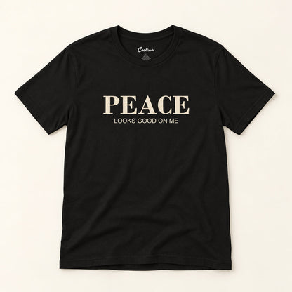 Peace Looks Good on Me affirmation tee in Black on a warm neutral studio background