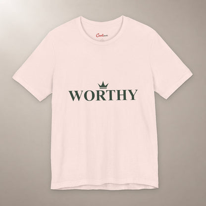 Her Worth Was Never in Question. Bella+Canvas 3001 T-shirt in Soft Pink, front flat lay with Worthy lettering and a small crown on a plain warm neutral background.