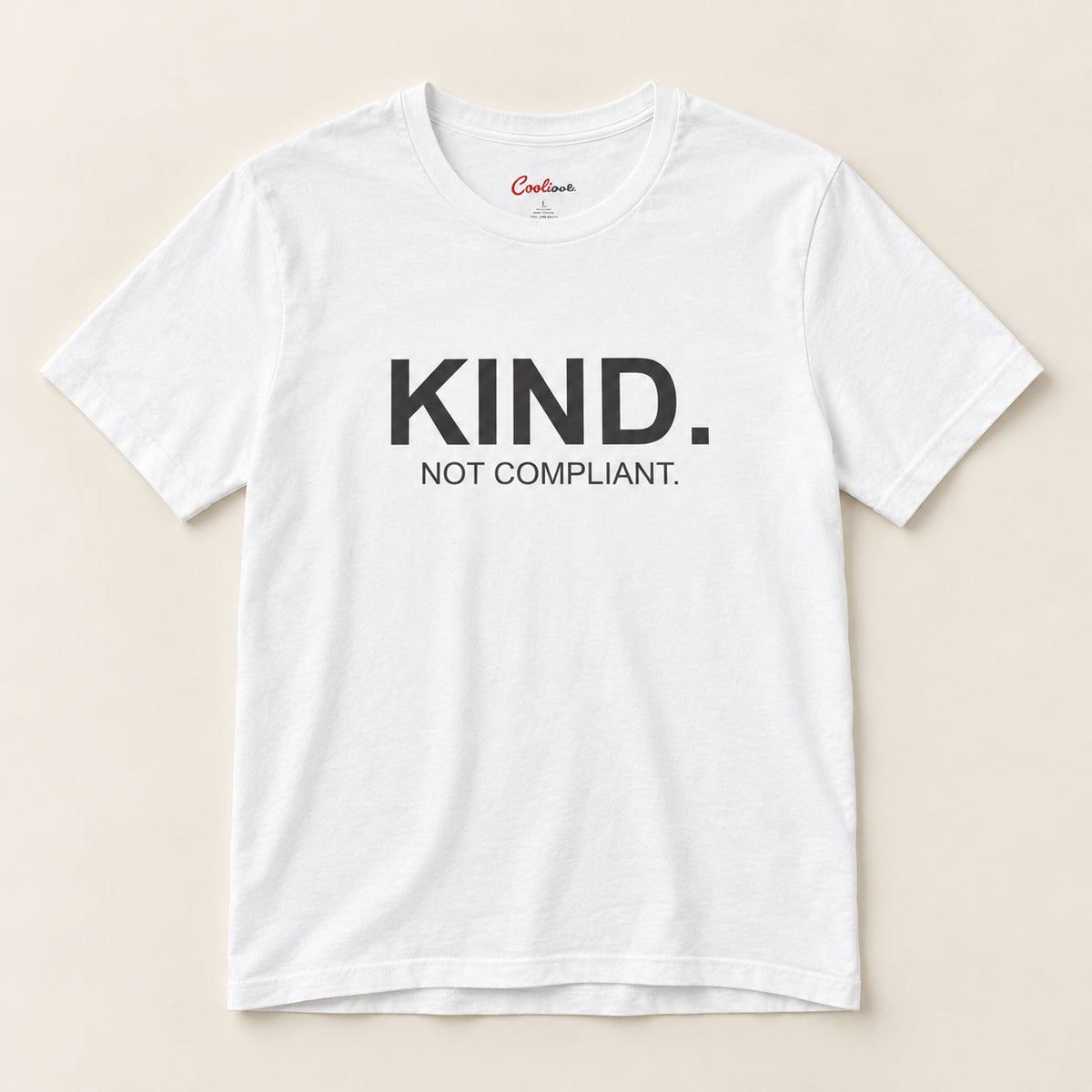 Kind. Not Compliant. affirmation tee in White on a neutral studio background