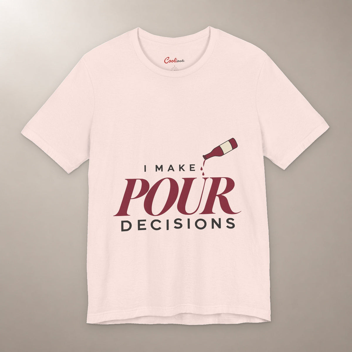 Blame the Vintage. Bella+Canvas 3001 T-shirt in Soft Pink, front flat lay with I Make Pour Decisions lettering and a tilted wine bottle on a plain warm neutral background.