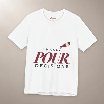 Blame the Vintage. Bella+Canvas 3001 T-shirt in White, front flat lay with I Make Pour Decisions lettering and a tilted wine bottle on a plain warm neutral background.