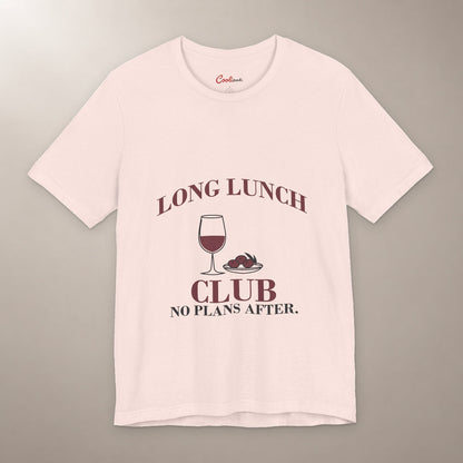 Lunch Is the Whole Agenda. Bella+Canvas 3001 T-shirt in Soft Pink, front flat lay with Long Lunch Club, No Plans After. lettering with a wine glass and olive dish on a plain warm neutral background.