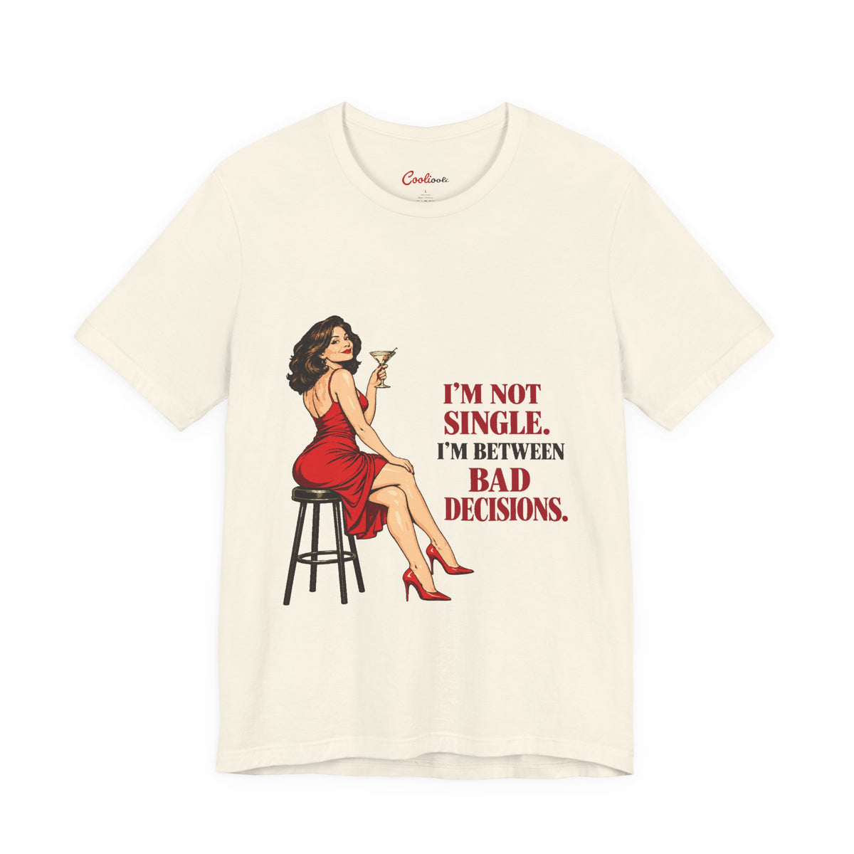Natural Bella+Canvas 3001 tee with a woman in a red dress holding a martini and “I'm not single. I'm between bad decisions.” lettering.