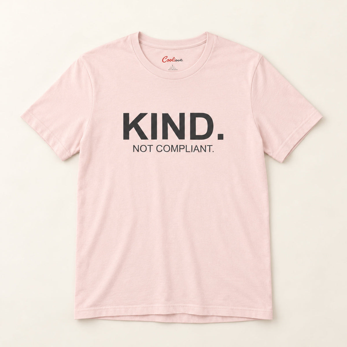 Kind. Not Compliant. affirmation tee in Soft Pink on a neutral studio background