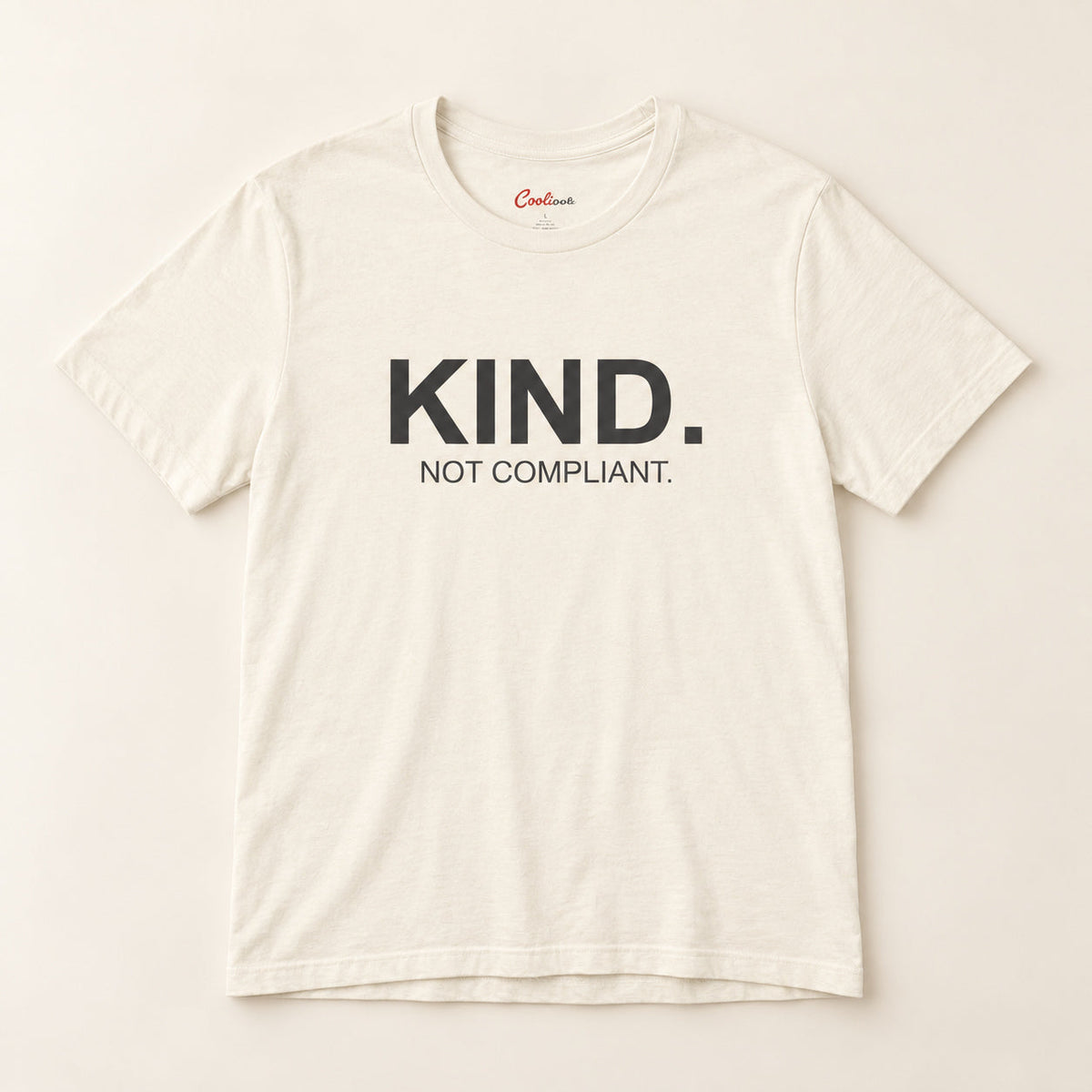 Kind. Not Compliant. affirmation tee in Natural on a neutral studio background