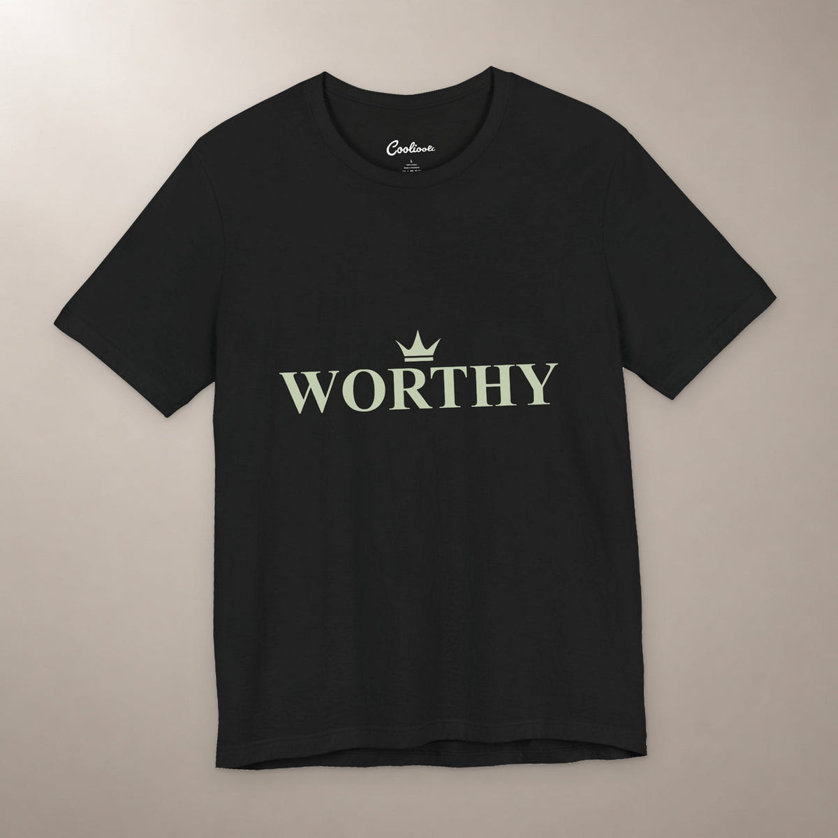 Her Worth Was Never in Question. Bella+Canvas 3001 T-shirt in Black, front flat lay with Worthy lettering and a small crown on a plain warm neutral background.