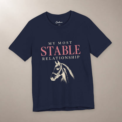 Finally, Someone Dependable. Bella+Canvas 3001 tee in navy, flat lay with My Most Stable Relationship lettering and a bridled horse on a plain warm neutral background.