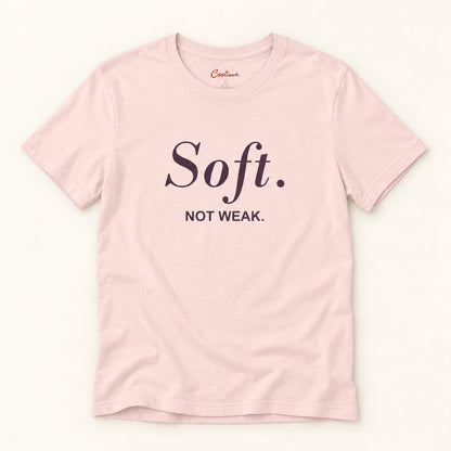 Soft. Not Weak. affirmation tee in Soft Pink on a warm neutral studio background