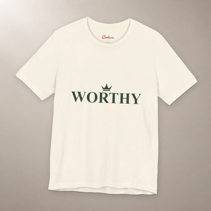 Her Worth Was Never in Question. Bella+Canvas 3001 T-shirt in Natural, front flat lay with Worthy lettering and a small crown on a plain warm neutral background.