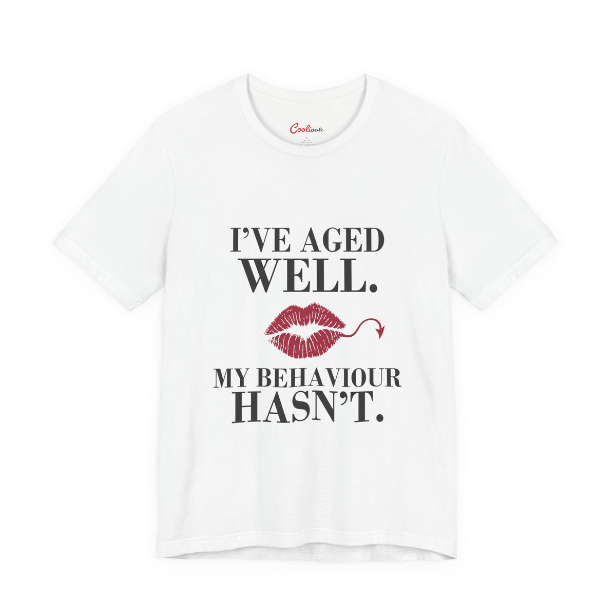 White Cooliooli Bella+Canvas 3001 T-shirt with “I’ve aged well. My behaviour hasn’t.” lettering and lipstick kiss with devil tail, front flat lay