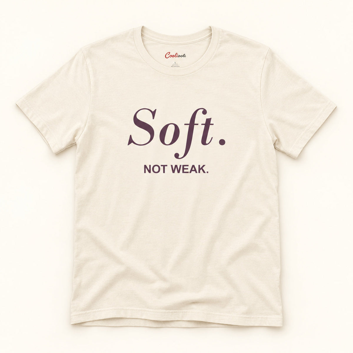 Soft. Not Weak. affirmation tee in Natural on a warm neutral studio background