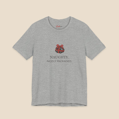 Athletic Heather Bella+Canvas 3001 Christmas T-shirt with an original coal and red bow illustration above Naughty. Nicely Packaged. lettering.