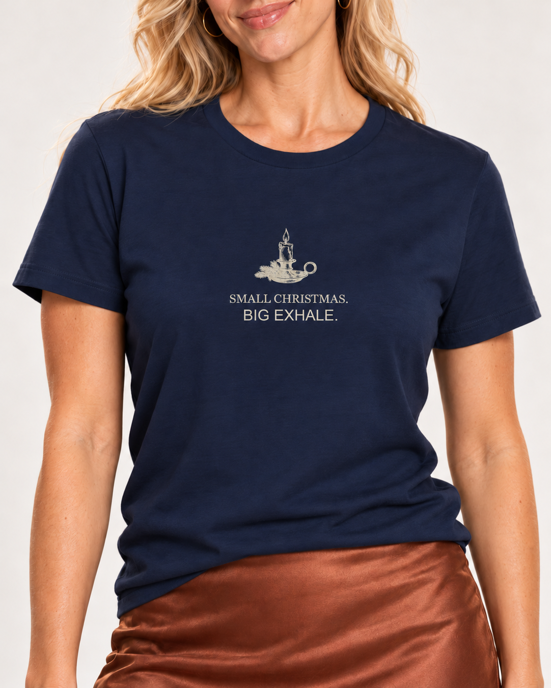 Close view of the pale candle and fir illustration with Small Christmas. Big Exhale. lettering on the Navy Bella+Canvas 3001 tee.