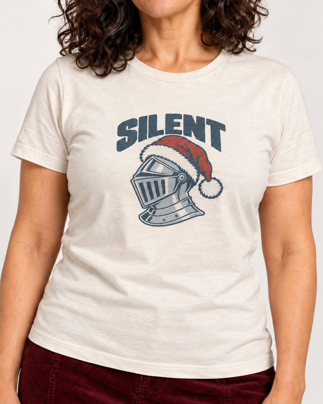 Collar-to-hip detail of the Natural Bella+Canvas 3001 unisex tee with SILENT lettering, silver-grey knight helmet and red Santa hat.