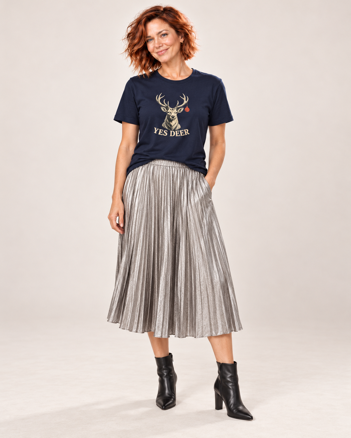 Sienna wearing the plain Navy YES DEER stag and one red bauble Bella+Canvas 3001 unisex tee with silver pleated midi skirt and black ankle boots.