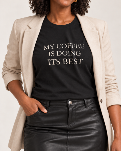 Close-up of the Black coffee slogan tee with matte ivory serif lettering following the cotton fold.
