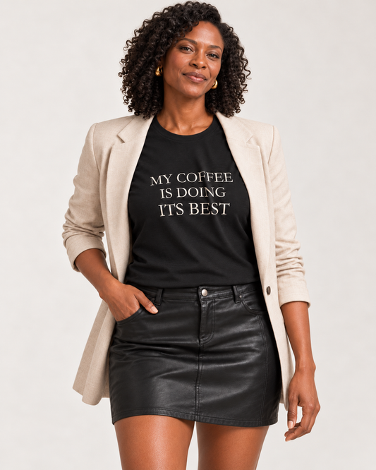 Amara wearing the Black My Coffee Is Doing Its Best Bella+Canvas3001 tee with an open beige blazer and black mini skirt.
