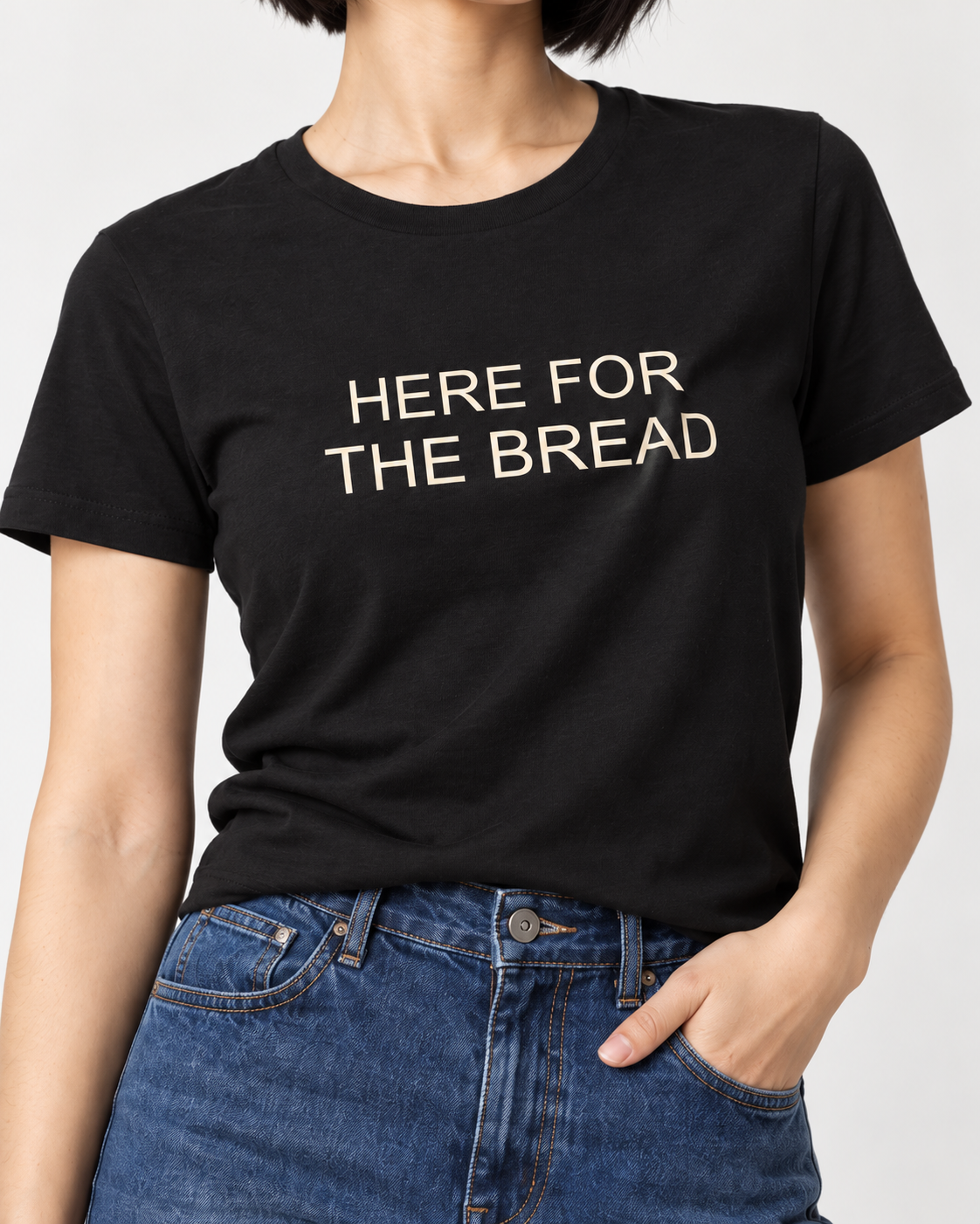 Close-up of cream Here for the Bread lettering on the black crewneck T-shirt.