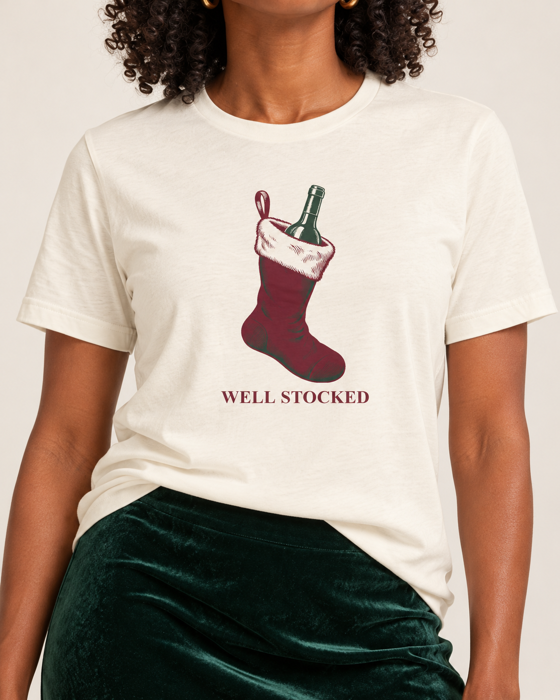 Collar-to-hip detail of the Natural Well Stocked T-shirt showing the solid red Christmas stocking, forest wine bottle and serif caption.