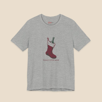 Athletic Heather Bella+Canvas3001 Well Stocked Christmas T-shirt with an original solid red wine-filled stocking illustration and serif lettering.