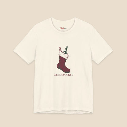 Natural Bella+Canvas3001 Well Stocked Christmas T-shirt with an original solid red wine-filled stocking illustration and serif lettering.