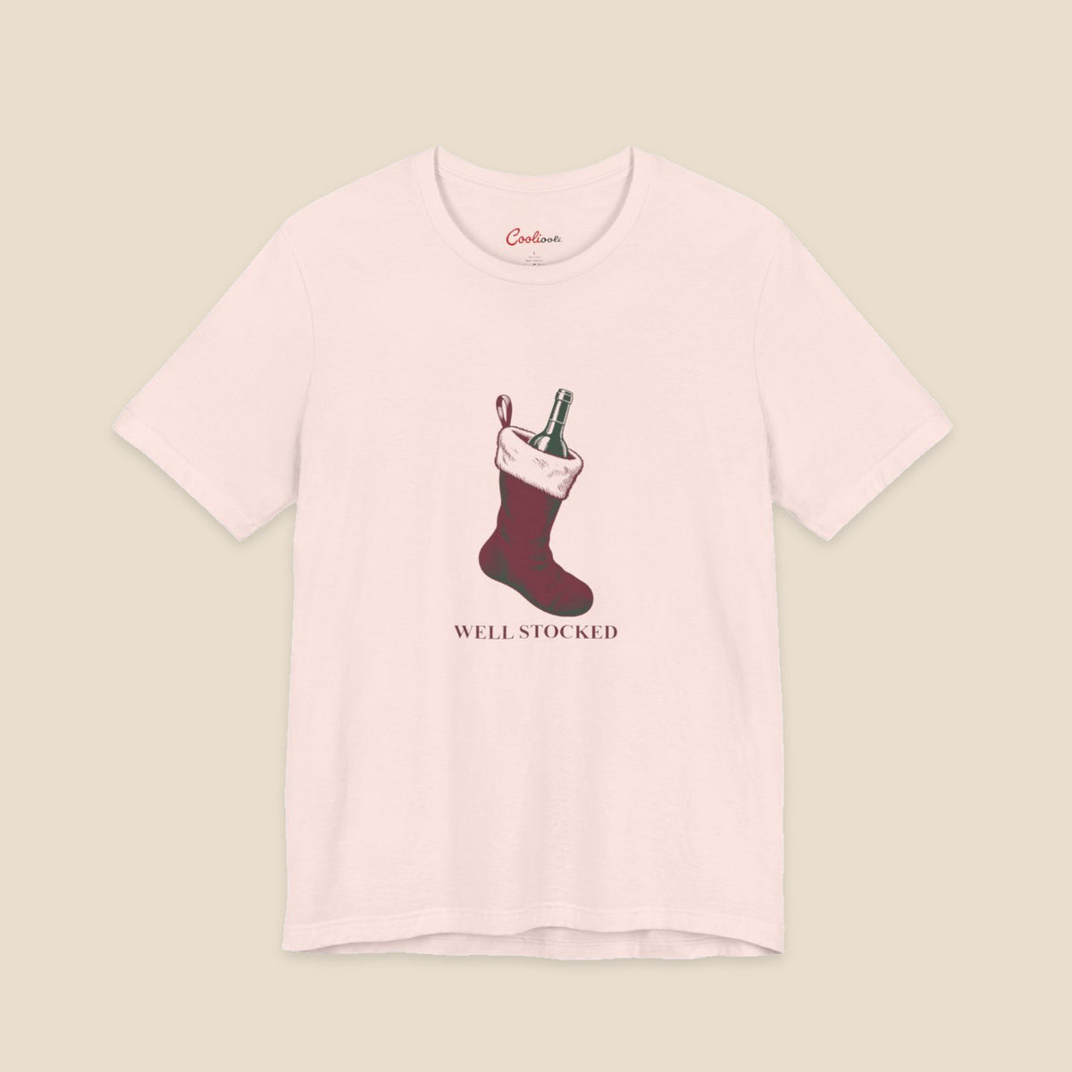 Soft Pink Bella+Canvas3001 Well Stocked Christmas T-shirt with an original solid red wine-filled stocking illustration and serif lettering.