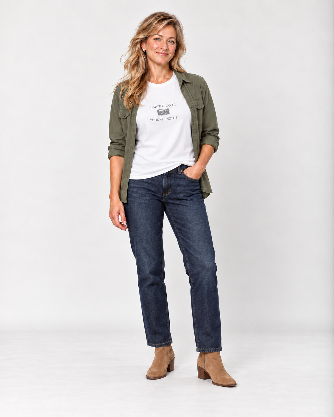 Elena wearing the White Saw the Light Took 47 Photos Bella+Canvas3001 unisex tee with an open olive overshirt, indigo jeans and tan suede ankle boots.