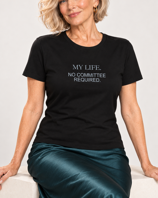 Collar-to-hip detail of the Black Bella+Canvas6400 women’s relaxed-fit tee with My Life No Committee Required pale blue-grey lettering and its shorter untucked hem.