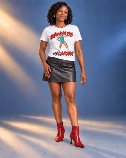 Amara wearing the White Wanna Be My Cardio tee with a black leather-look miniskirt and cherry-red heeled ankle boots in a blue studio.