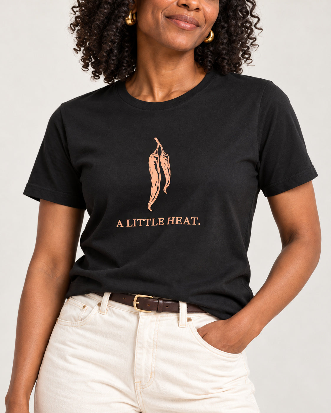Matching collar-to-hip detail of Black Bella+Canvas3001, showing the exact A LITTLE HEAT. print and jersey.
