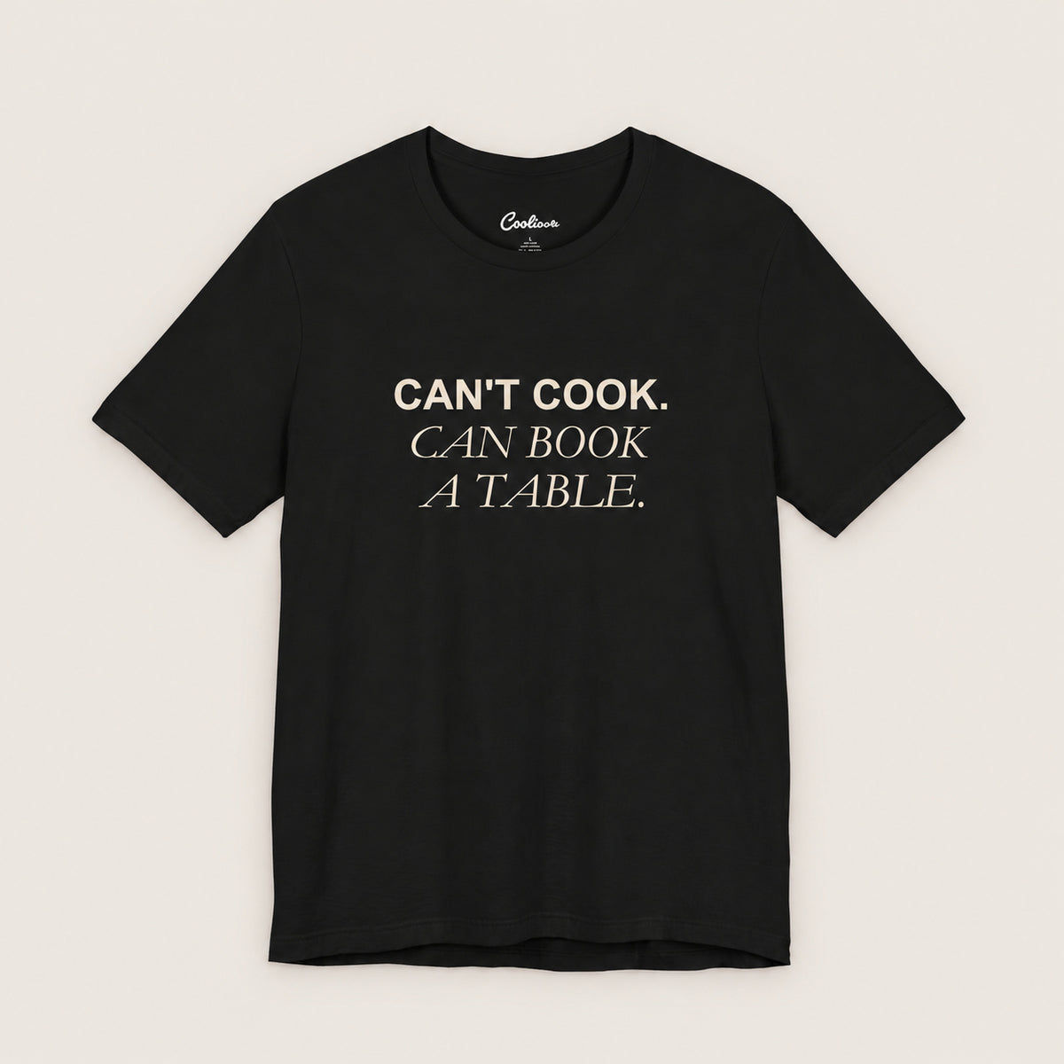 Can't Cook, Can Book a Table Bella+Canvas 3001 T-shirt in Black, front flat lay.