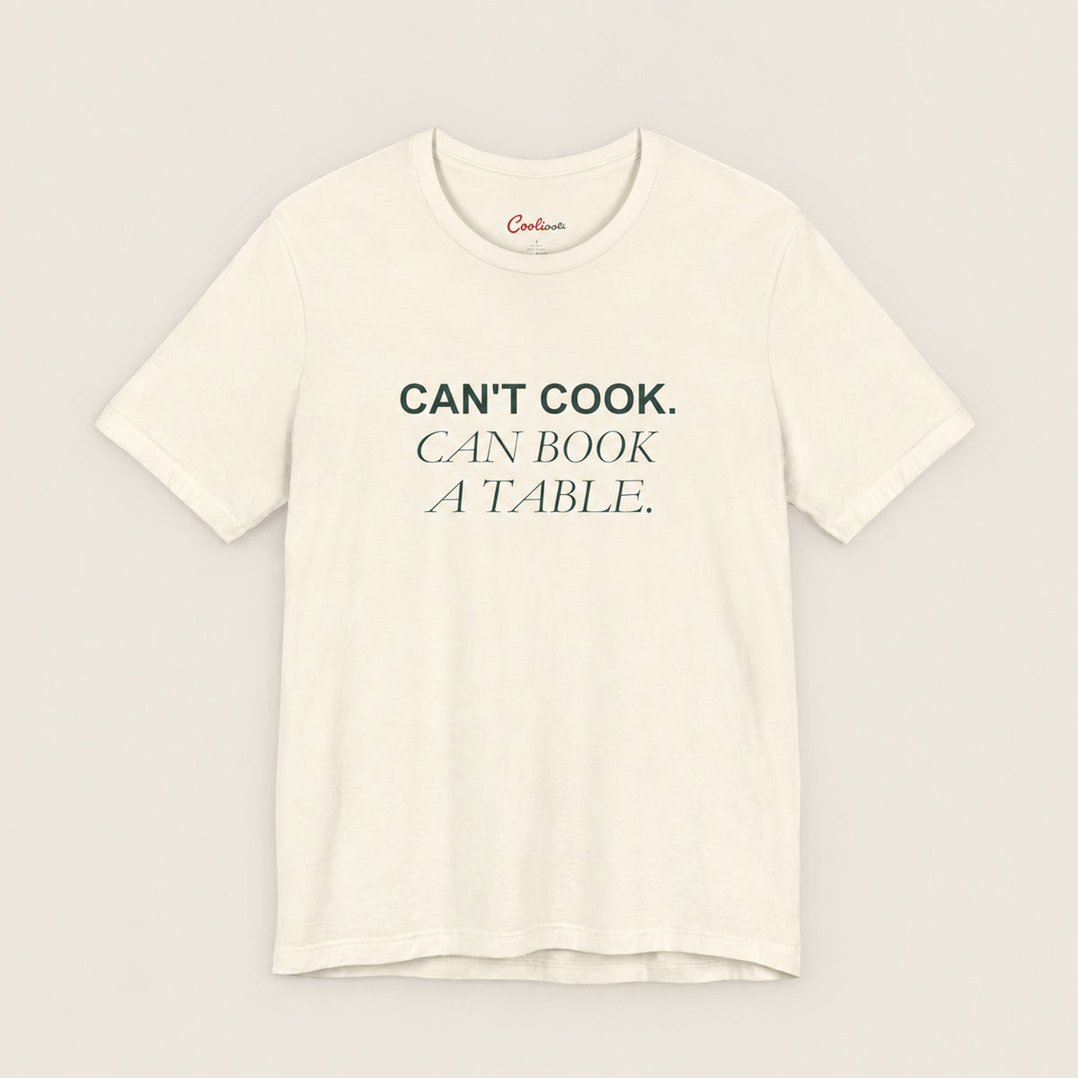 Can't Cook, Can Book a Table Bella+Canvas 3001 T-shirt in Natural, front flat lay.