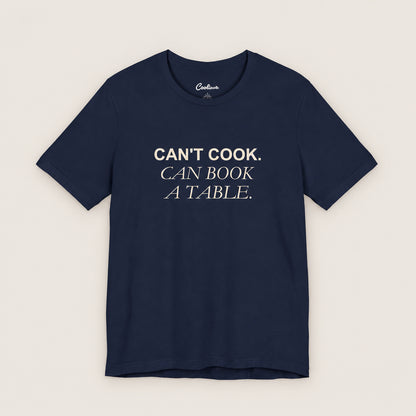 Can't Cook, Can Book a Table Bella+Canvas 3001 T-shirt in Navy, front flat lay.
