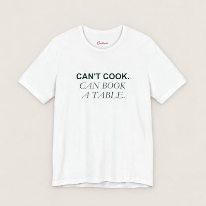 Can't Cook, Can Book a Table Bella+Canvas 3001 T-shirt in White, front flat lay.
