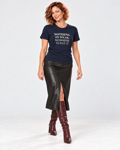 Sienna wearing the Navy Bella+Canvas3001 T-shirt with black leather-look midi skirt with a front walking slit and burgundy heeled knee-high boots. Exact print: NOTHING TO WEAR. NOWHERE TO PUT IT.