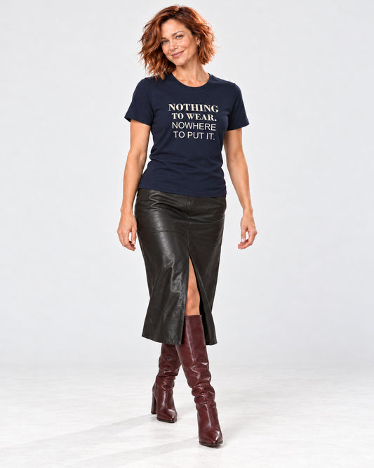 Sienna wearing the Navy Bella+Canvas3001 T-shirt with black leather-look midi skirt with a front walking slit and burgundy heeled knee-high boots. Exact print: NOTHING TO WEAR. NOWHERE TO PUT IT.