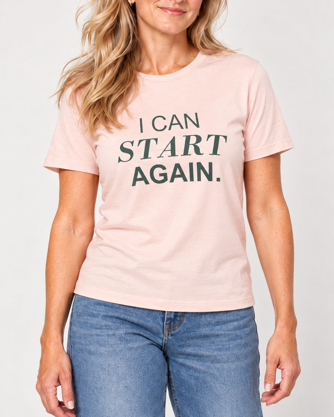 Elena wearing the Soft Pink I CAN START AGAIN. Bella+Canvas 3001 tee — collar-to-hip print detail