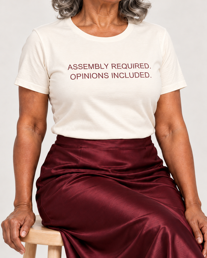 Close-up of the muted burgundy Assembly Required. Opinions Included. lettering on the Natural cotton crewneck T-shirt.