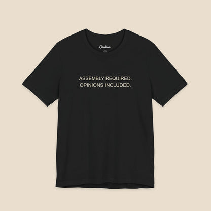 Black Bella+Canvas 3001 T-shirt with Assembly Required. Opinions Included. printed in two clean sans-serif lines.