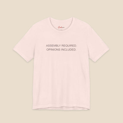 Soft Pink Bella+Canvas 3001 T-shirt with Assembly Required. Opinions Included. printed in two clean sans-serif lines.