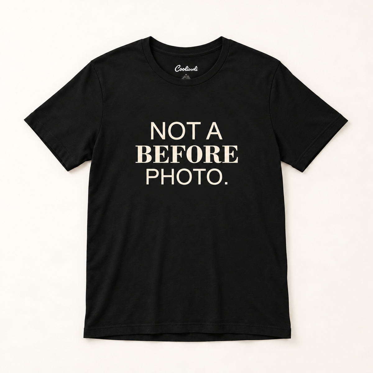 NOT A BEFORE PHOTO. Bella+Canvas 3001 tee in Black, overhead view on a plain warm neutral studio background