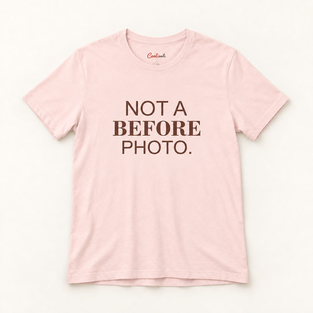 NOT A BEFORE PHOTO. Bella+Canvas 3001 tee in Soft Pink, overhead view on a plain warm neutral studio background